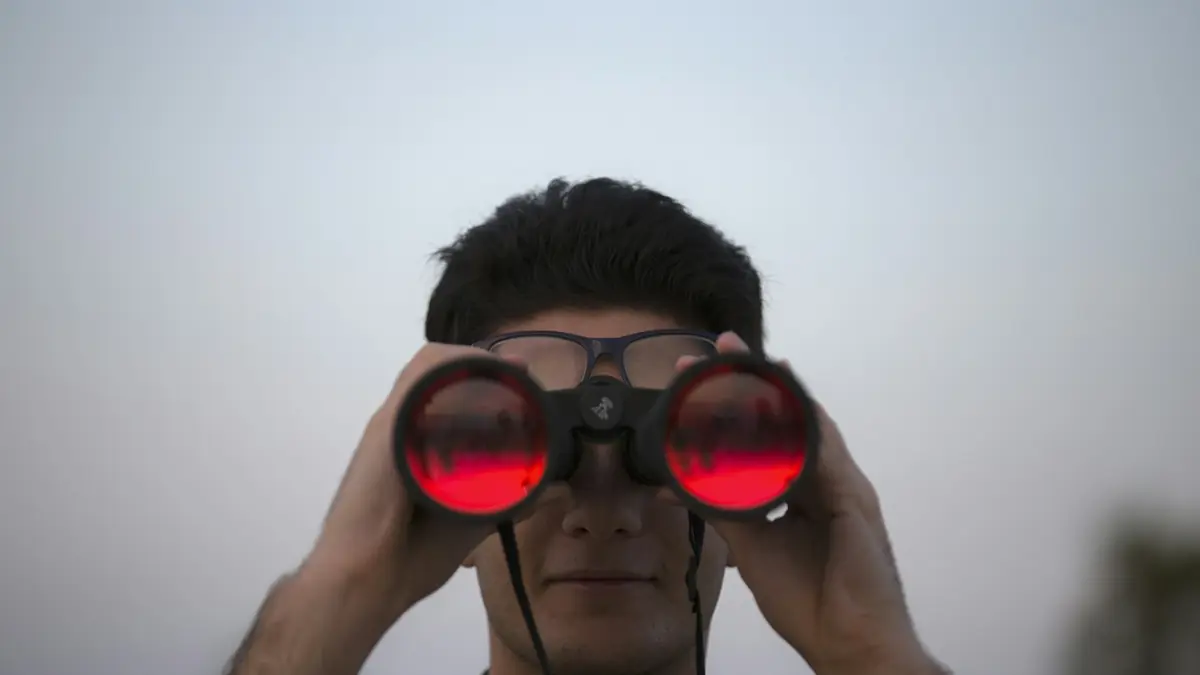 person holding black binoculars